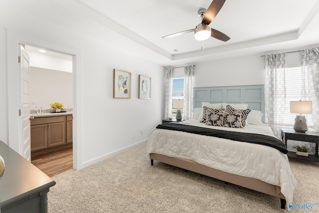 bedroom featuring light carpet, multiple windows, ensuite bath, and ceiling fan