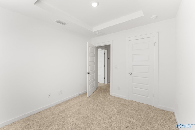 unfurnished bedroom featuring light carpet and a closet