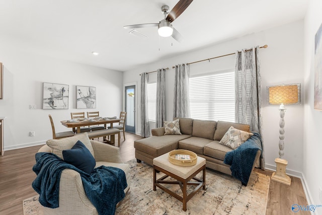 living room featuring light wood-type flooring and ceiling fan