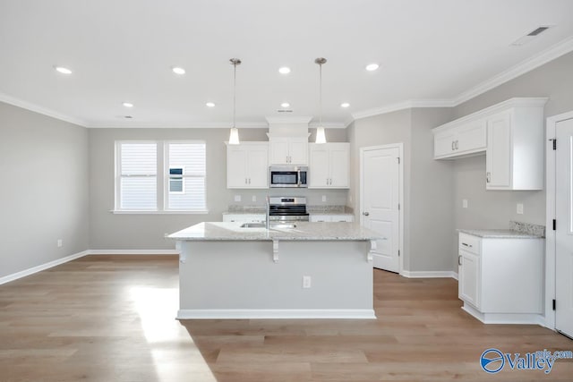 kitchen featuring white cabinets, a kitchen island with sink, appliances with stainless steel finishes, and decorative light fixtures