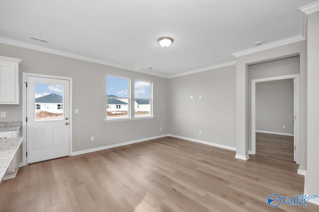 interior space featuring crown molding and light hardwood / wood-style flooring