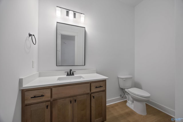 bathroom featuring hardwood / wood-style flooring, vanity, and toilet