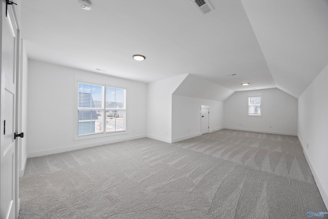 additional living space with vaulted ceiling and light colored carpet