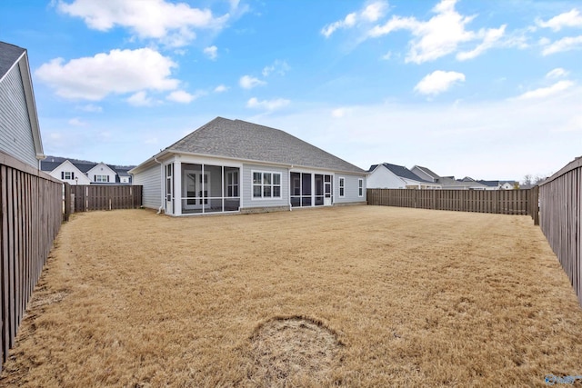 rear view of property with a lawn and a sunroom