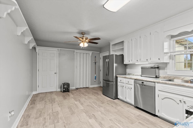 kitchen with ceiling fan, sink, appliances with stainless steel finishes, white cabinets, and light wood-type flooring