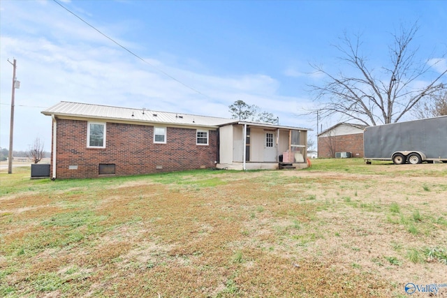 back of house with cooling unit and a lawn