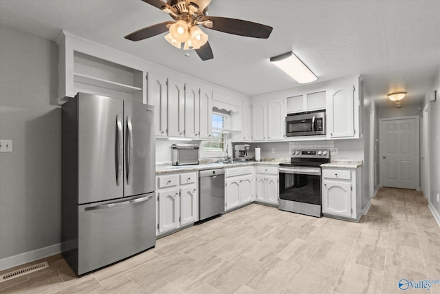 kitchen featuring ceiling fan, white cabinetry, and stainless steel appliances