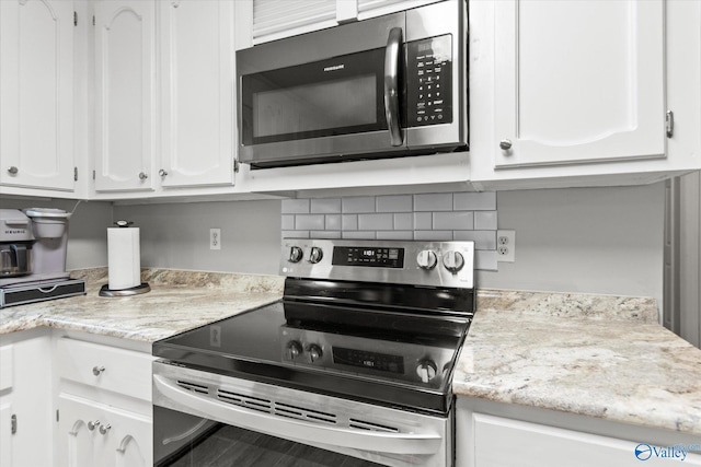 kitchen with backsplash, white cabinetry, and appliances with stainless steel finishes