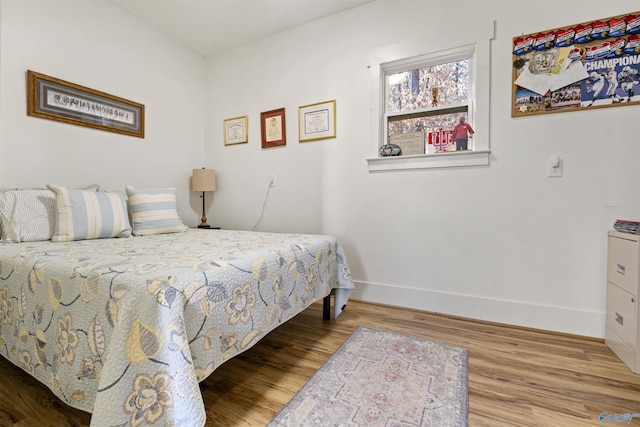 bedroom with baseboards and wood finished floors