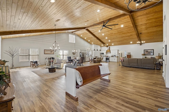 living room with high vaulted ceiling, wooden ceiling, ceiling fan with notable chandelier, wood finished floors, and beamed ceiling