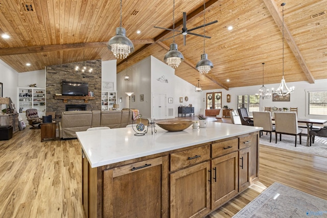 kitchen featuring open floor plan, light countertops, a kitchen island, and decorative light fixtures