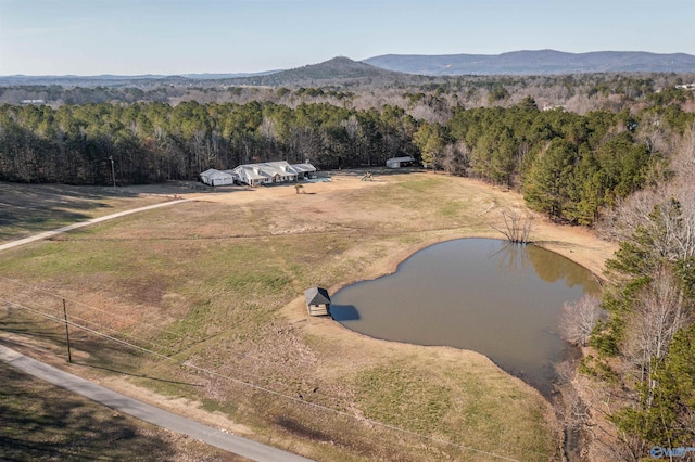 aerial view with a water and mountain view and a view of trees