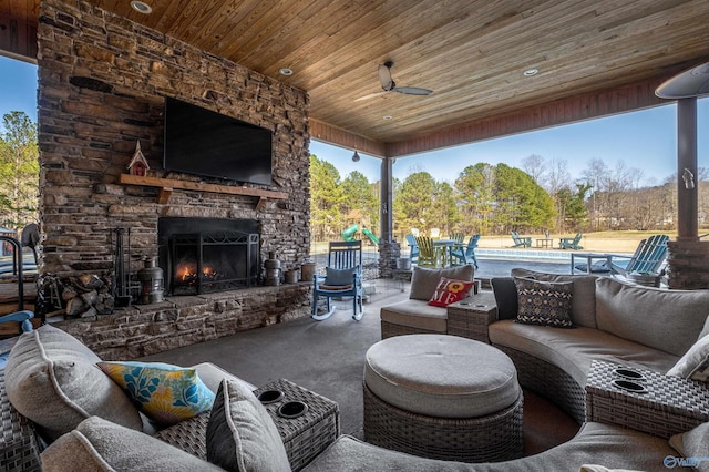 view of patio with an outdoor living space with a fireplace, a swimming pool, and a ceiling fan