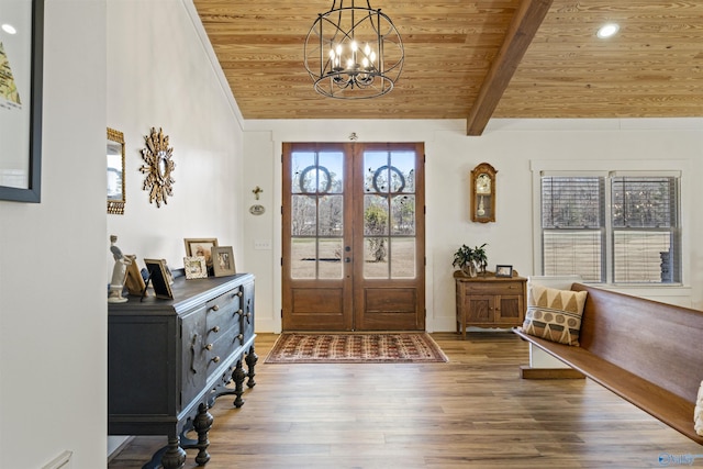 foyer entrance featuring lofted ceiling with beams, wood ceiling, wood finished floors, french doors, and a chandelier