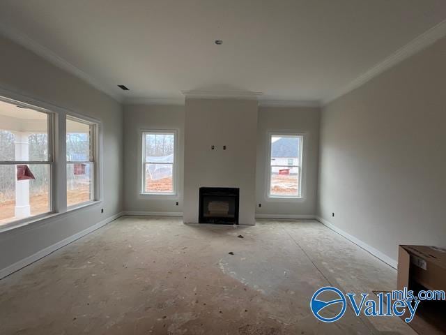 unfurnished living room featuring crown molding and plenty of natural light