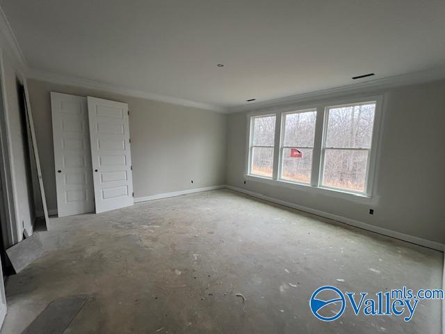 empty room featuring crown molding and concrete floors