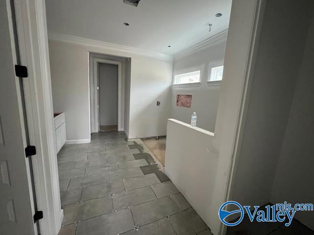 corridor with crown molding and light tile patterned flooring