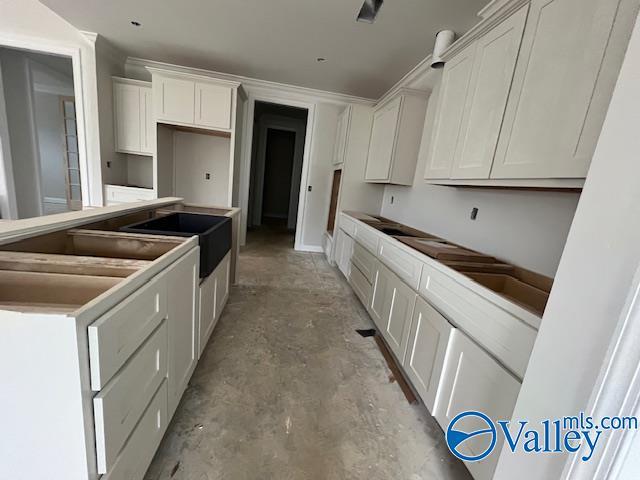 kitchen with sink, stovetop, and white cabinets