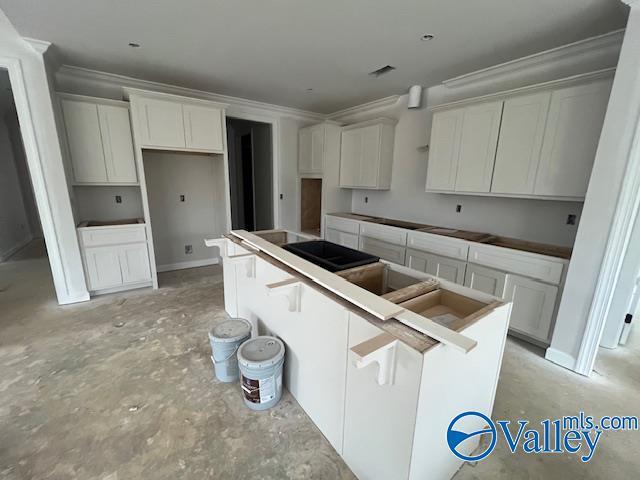 kitchen featuring ornamental molding, a center island, and white cabinets