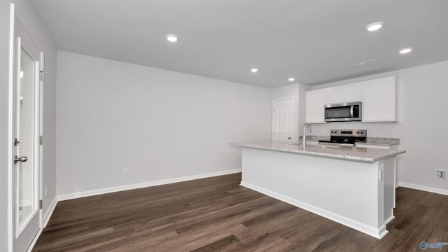 kitchen featuring sink, stainless steel appliances, an island with sink, white cabinets, and dark hardwood / wood-style flooring