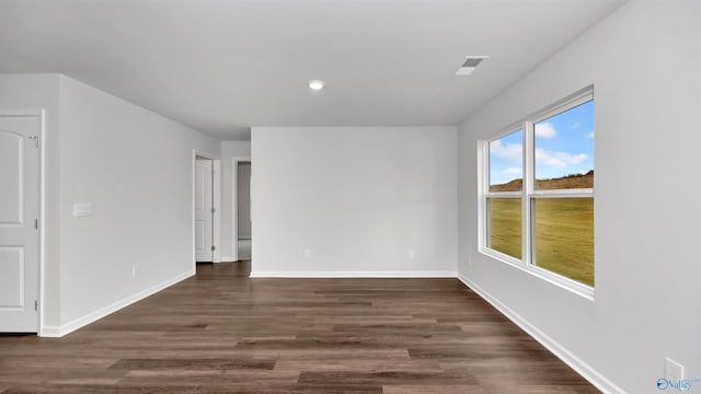 unfurnished room with dark wood-type flooring