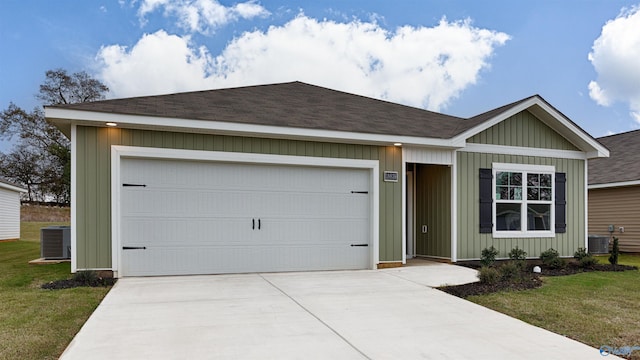 ranch-style house with cooling unit, a garage, and a front lawn