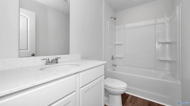 full bathroom with wood-type flooring, toilet,  shower combination, and vanity