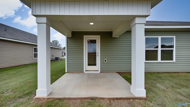 doorway to property with a yard, a patio area, and central air condition unit