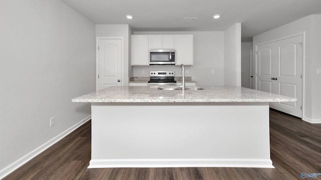 kitchen with sink, light stone counters, an island with sink, stainless steel appliances, and white cabinets