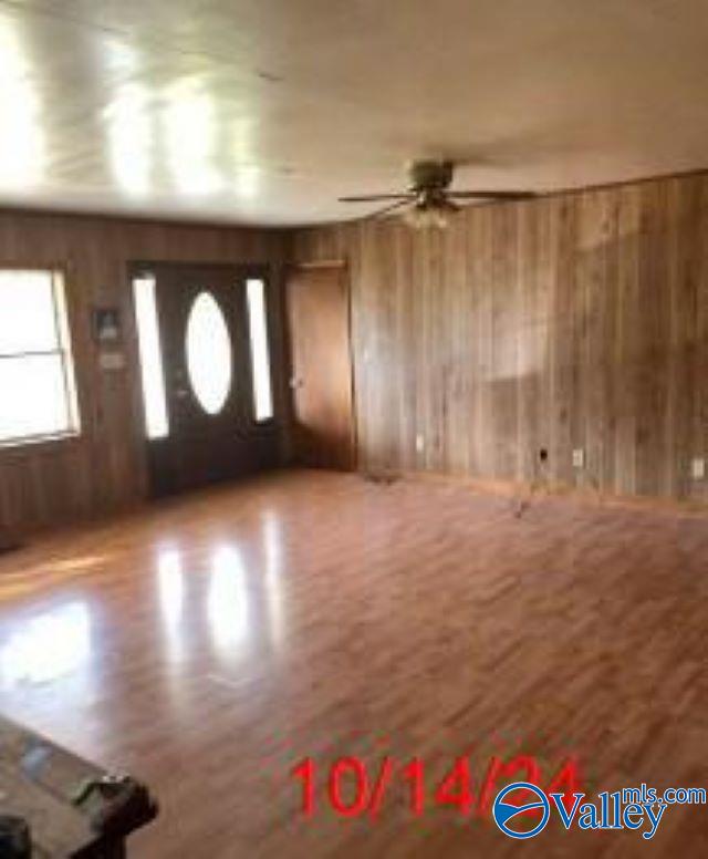 1607 Tennessee St, Sheffield, AL 35660 - entrance foyer featuring wood walls, ceiling fan, and wood finished floors