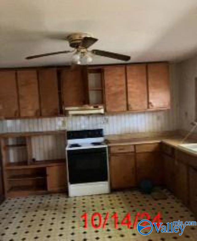 1607 Tennessee St, Sheffield, AL 35660 - kitchen with brown cabinets, a ceiling fan, electric range oven, under cabinet range hood, and light countertops