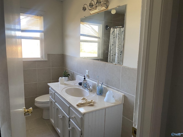 bathroom with tile walls, tile patterned floors, vanity, and toilet