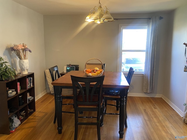 dining space with an inviting chandelier and light hardwood / wood-style flooring