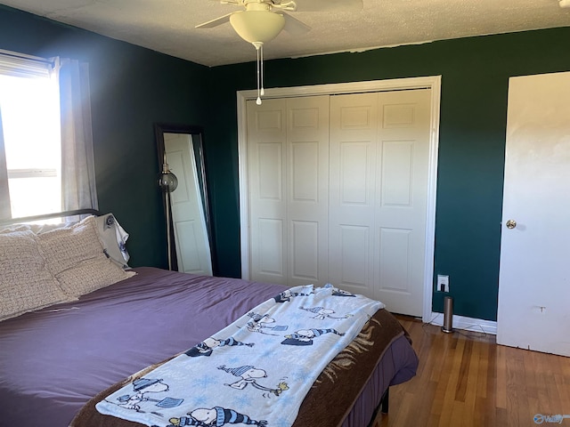 bedroom with ceiling fan, a closet, a textured ceiling, and wood-type flooring