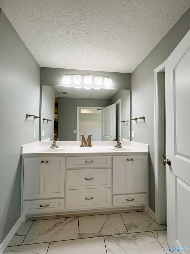 1575 Cottage Ln, Southside, AL 35907 - full bath featuring marble look tiles, baseboards, double vanity, and a textured ceiling