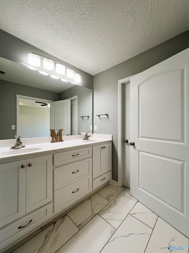 1575 Cottage Ln, Southside, AL 35907 - full bath featuring marble look tiles, double vanity, and a textured ceiling