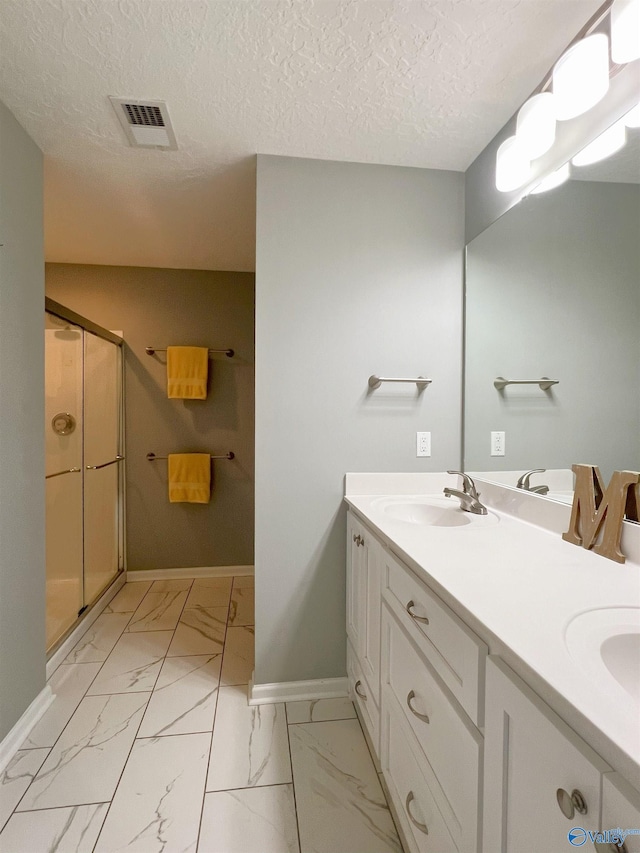 1575 Cottage Ln, Southside, AL 35907 - bathroom featuring baseboards, a stall shower, marble look tile flooring, double vanity, and a textured ceiling