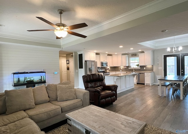 1575 Cottage Ln, Southside, AL 35907 - living room featuring dark wood-type flooring, a raised ceiling, crown molding, ceiling fan, and a chandelier