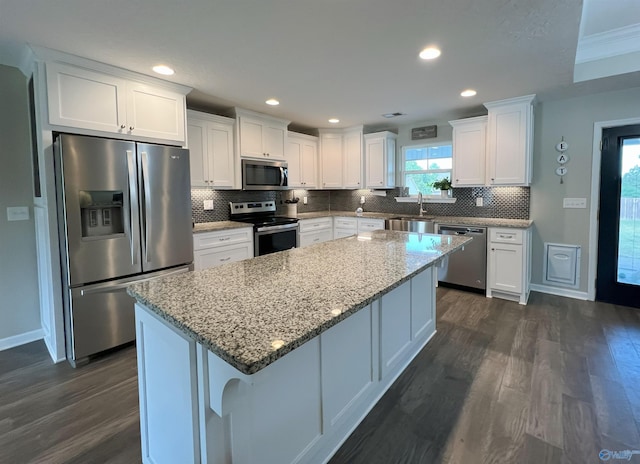 1575 Cottage Ln, Southside, AL 35907 - kitchen with appliances with stainless steel finishes, dark wood-style floors, white cabinetry, backsplash, and a kitchen island