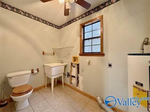 bathroom with tile patterned flooring, ceiling fan, water heater, and toilet