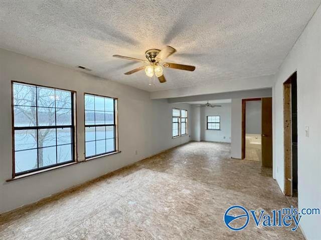 empty room with a textured ceiling and ceiling fan