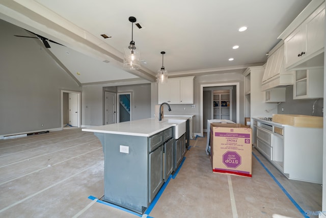 kitchen featuring a large island with sink, decorative light fixtures, white cabinetry, sink, and ceiling fan