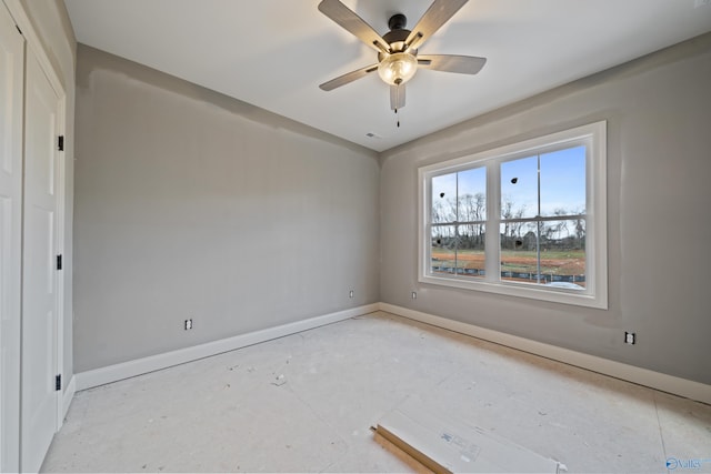 spare room featuring ceiling fan and baseboards