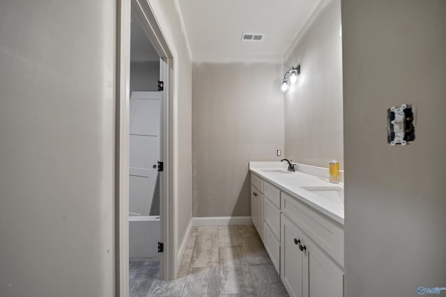 bathroom with visible vents, a sink, baseboards, and double vanity