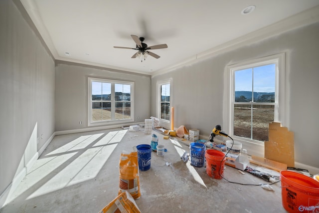 unfurnished room with ceiling fan, a healthy amount of sunlight, crown molding, and a mountain view