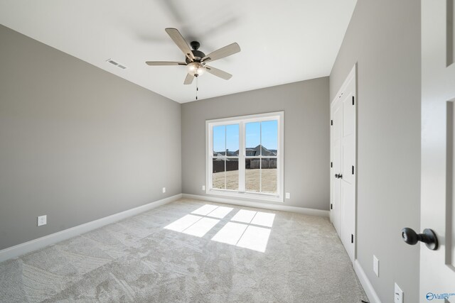 spare room featuring a ceiling fan, carpet flooring, visible vents, and baseboards