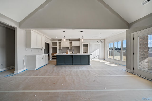 kitchen featuring an inviting chandelier, a large island, vaulted ceiling, pendant lighting, and white cabinets