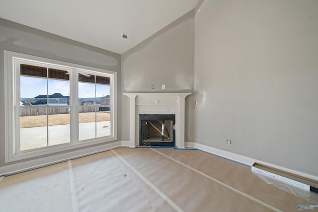 unfurnished living room featuring lofted ceiling, visible vents, and a fireplace