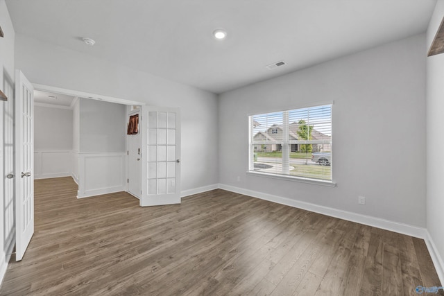 unfurnished room featuring french doors, visible vents, wood finished floors, baseboards, and recessed lighting