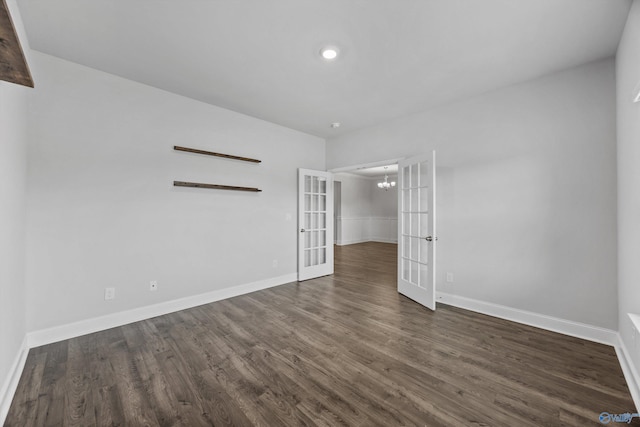 unfurnished bedroom with baseboards, french doors, dark wood finished floors, and a chandelier